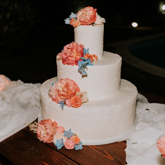 White wedding cake with pastel wedding flowers