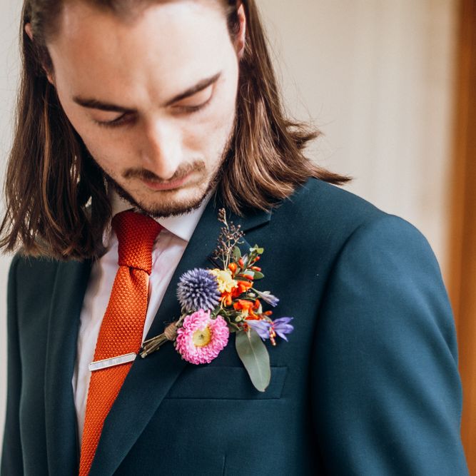Floral Buttonhole with Orange Tie and Navy Suit