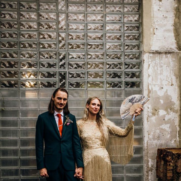 Groom in Navy Suit with Orange Tie and Bride in Gold Wedding Dress