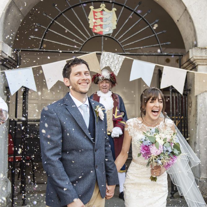 Bride in Lacy Fishtail Stella York Gown with Plunging V Back and Diamante Charm on Champagne Ribbon Belt | Summer Bridal Bouquet with Purple and Blue Flowers and Eucalyptus | Groom in Blue Jacket and Waistcoat with Camel Chinos | Bridesmaids in Baby Blue Dresses by Quiz with V Neck and Short Floaty Sleeves | Giant Pastel Bunting Flags | Wedding Ceremony at Rye Town Hall | Morris Minor Wedding Car, Hanging Flowers in Bottles and Town Crier for Village Hall Wedding in Rye | Eleanor Jane Photography
