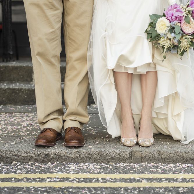 Bride in Lacy Fishtail Stella York Gown with Plunging V Back and Diamante Charm on Champagne Ribbon Belt | Summer Bridal Bouquet with Purple and Blue Flowers and Eucalyptus | Floral Embroidered Chloe Shoes by Bella Belle | Groom in Blue Jacket and Waistcoat with Camel Chinos | Morris Minor Wedding Car, Hanging Flowers in Bottles and Town Crier for Village Hall Wedding in Rye | Eleanor Jane Photography