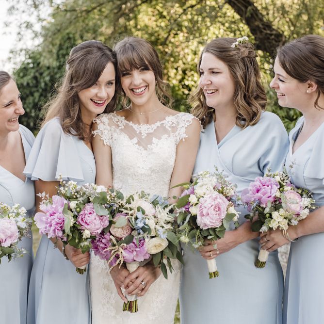 Bride in Lacy Fishtail Stella York Gown with Plunging V Back and Diamante Charm on Champagne Ribbon Belt | Bridesmaids in Baby Blue Dresses by Quiz with V Neck and Short Floaty Sleeves | Summer Wedding Bouquets with Purple and Blue Flowers and Eucalyptus | Morris Minor Wedding Car, Hanging Flowers in Bottles and Town Crier for Village Hall Wedding in Rye | Eleanor Jane Photography