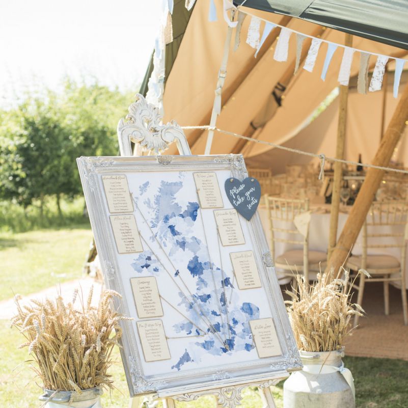 Table Plan in Rustic Frame | Milk Churns | Tipi Wedding Reception at Udimore Village Hall, East Sussex | Morris Minor Wedding Car, Hanging Flowers in Bottles and Town Crier for Village Hall Wedding in Rye | Eleanor Jane Photography