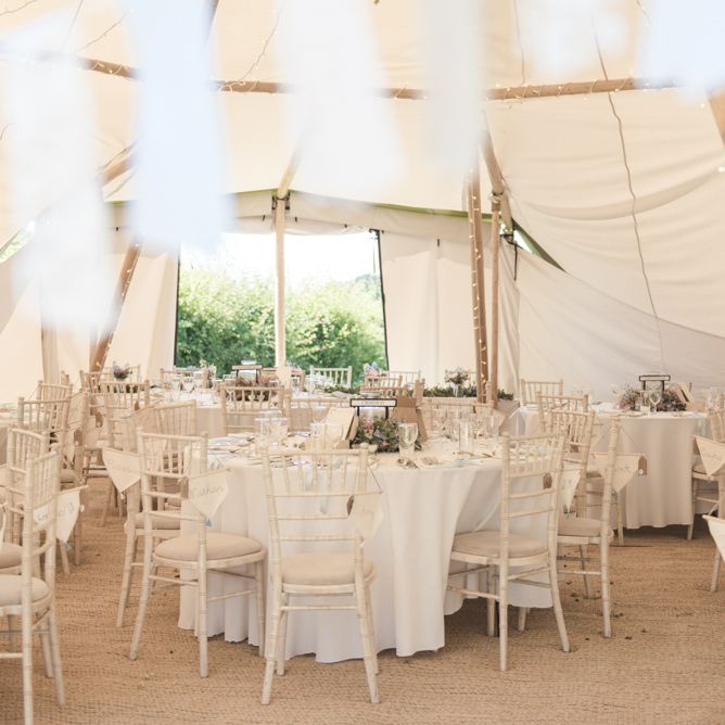 Personalised Flag Wedding Favours | Fairy Lights | Bunting | Flower Garland Centrepieces | Tipi Wedding Reception at Udimore Village Hall, East Sussex | Morris Minor Wedding Car, Hanging Flowers in Bottles and Town Crier for Village Hall Wedding in Rye | Eleanor Jane Photography