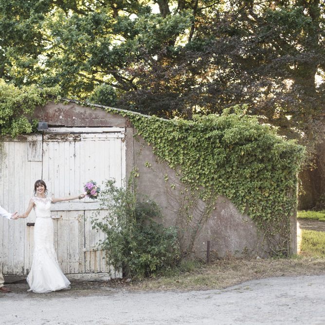 Bride in Lacy Fishtail Stella York Gown with Plunging V Back and Diamante Charm on Champagne Ribbon Belt | Summer Bridal Bouquet with Purple and Blue Flowers and Eucalyptus | Groom in Blue Jacket and Waistcoat with Camel Chinos | Morris Minor Wedding Car, Hanging Flowers in Bottles and Town Crier for Village Hall Wedding in Rye | Eleanor Jane Photography