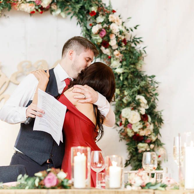 Wedding Reception Speeches | Floral Hoop | Top Table Decor | Bride in Bespoke Red Gown from agape Bridal Boutique | Groom in Slaters Suit | Red New Years Eve Winter Wedding at Iscoyd Park, Shropshire | White Stag Wedding Photography | Lovetwofilm