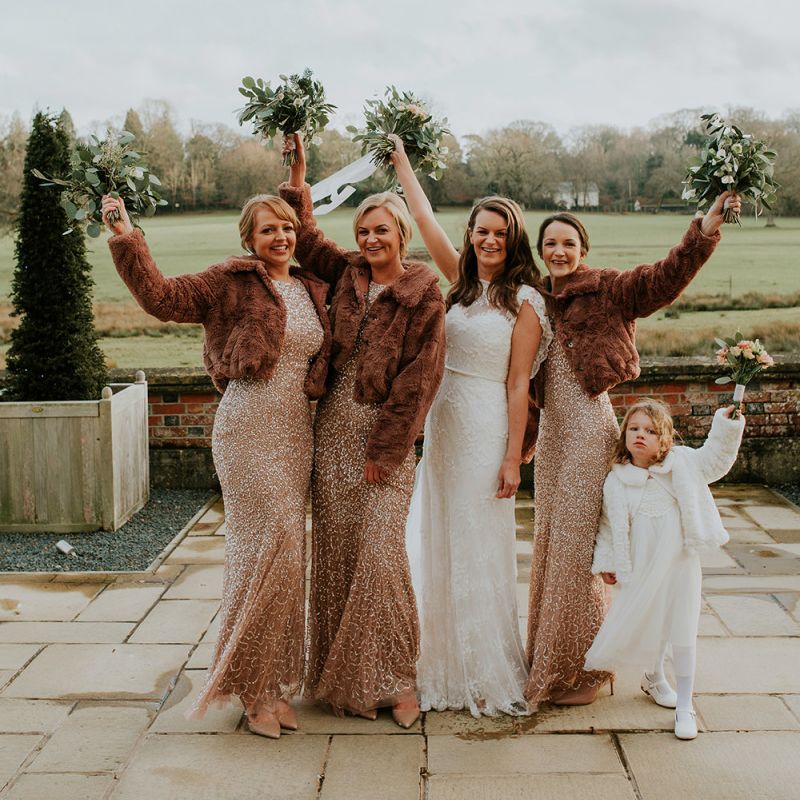 Bridesmaids in sequin dresses with cover ups for winter wedding