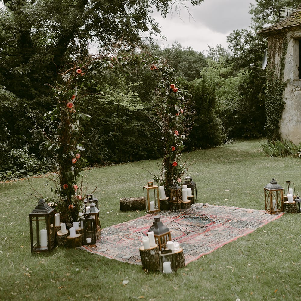 Floral Arch, Persian Rug &amp; Lanterns Wedding Decor | Outdoor Boho Wedding at Chateau le Tour, France | Adam and Grace Photography | Head and Heart Films