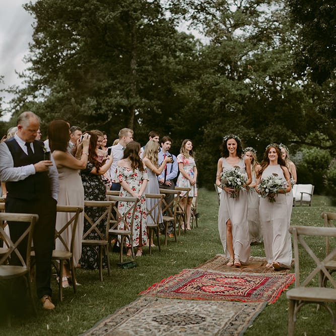 Outdoor Wedding Ceremony | Bridesmaid Entrance in Show me Your Mumu Dresses | Persian Rug, &amp; Floral Arch Aisle &amp; Altar Wedding Decor | Outdoor Boho Wedding at Chateau le Tour, France | Adam and Grace Photography | Head and Heart Films