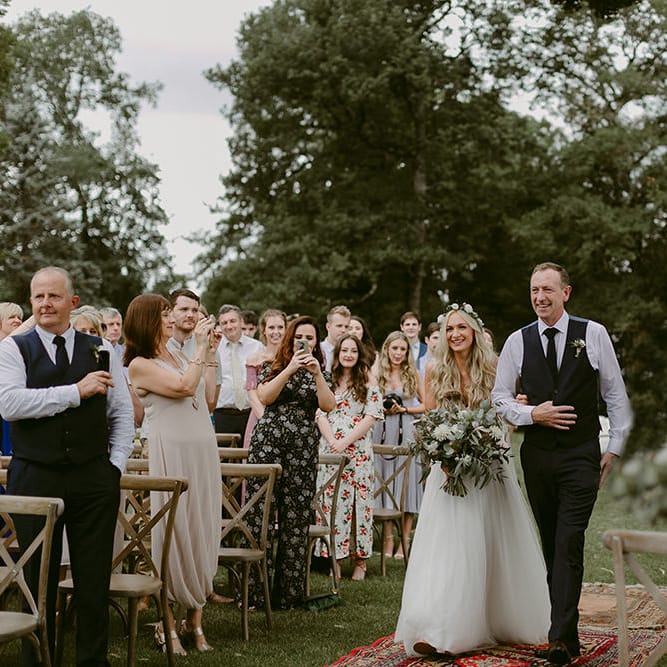 Outdoor Wedding Ceremony | Bridal Entrance in Daarlarna Wedding Dress | Persian Rug, &amp; Floral Arch Aisle &amp; Altar Wedding Decor | Outdoor Boho Wedding at Chateau le Tour, France | Adam and Grace Photography | Head and Heart Films