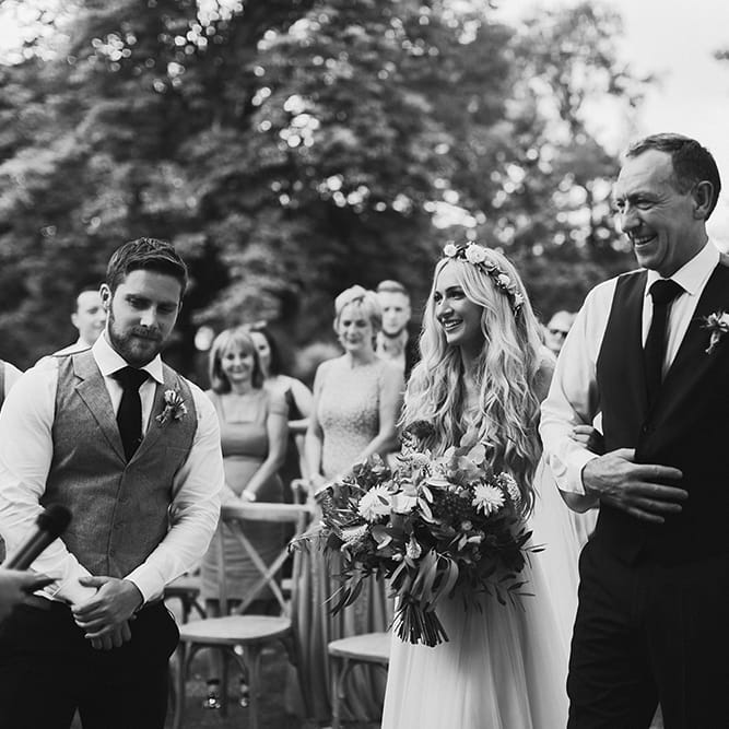 Outdoor Wedding Ceremony | Bridal Entrance in Daarlarna Wedding Dress | Persian Rug, &amp; Floral Arch Aisle &amp; Altar Wedding Decor | Outdoor Boho Wedding at Chateau le Tour, France | Adam and Grace Photography | Head and Heart Films