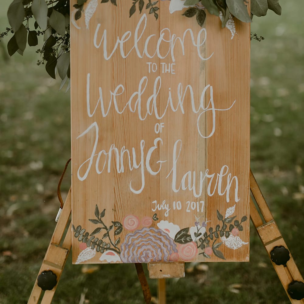 Wooden Wedding Welcome Sign with Greenery Decor | Outdoor Boho Wedding at Chateau le Tour, France | Adam and Grace Photography | Head and Heart Films