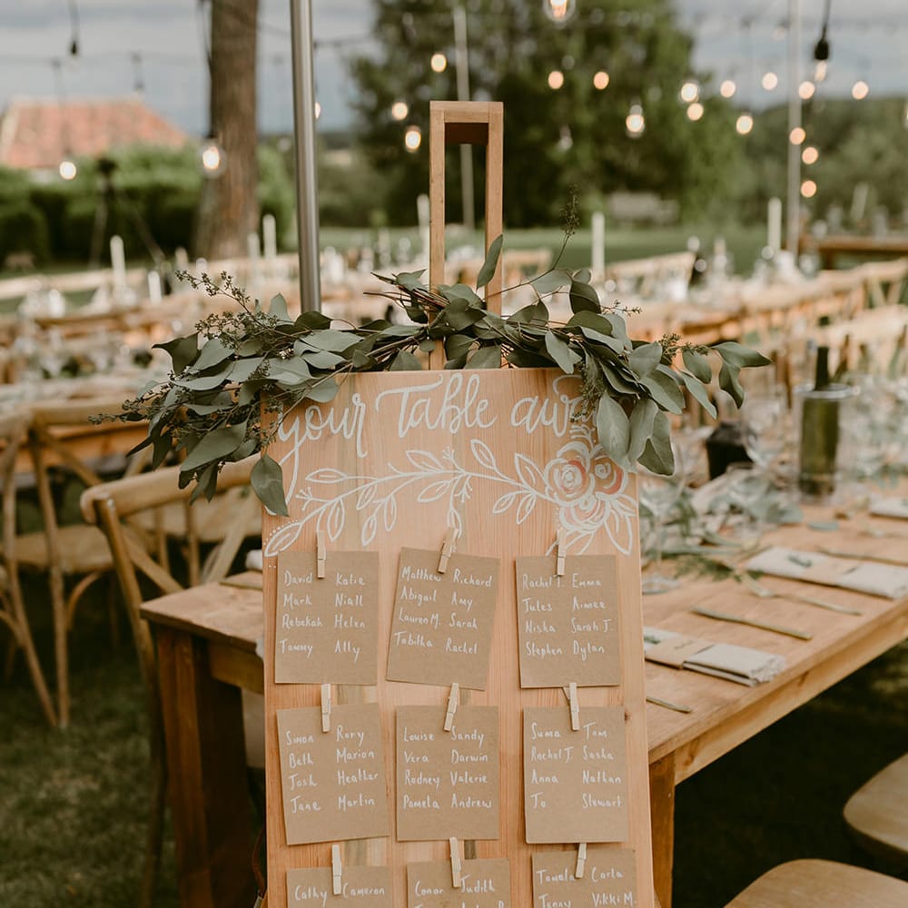 Wooden Table Plan with Greenery Decor | Festoon Lit Outdoor Boho Wedding at Chateau le Tour, France | Adam and Grace Photography | Head and Heart Films