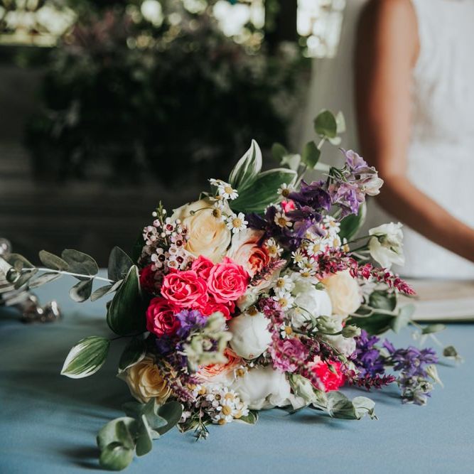 Pink wedding bouquet for bride at wedding with different bridesmaid dresses