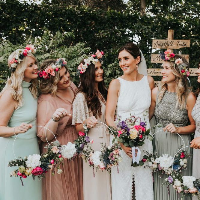 Different bridesmaid dresses with hoop bouquets and flower crowns