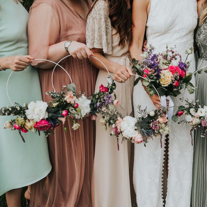 Bridal party in different bridesmaid dresses with hoop bouquets