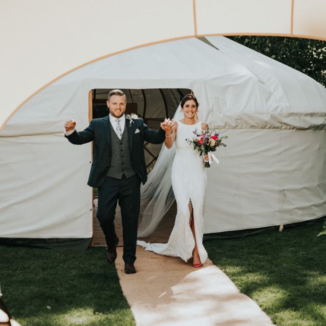 Bride and groom enter wedding marquee with Bridal party in different bridesmaid dresses with hoop bouquets