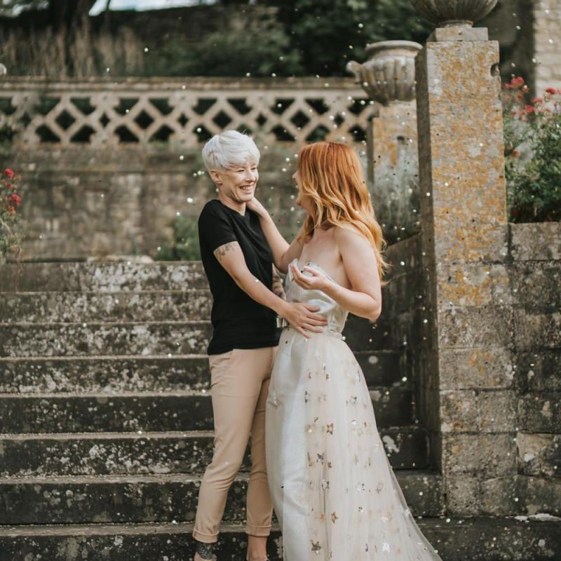 LGBTQ+ wedding confetti moment with bride in bridal jumpsuit