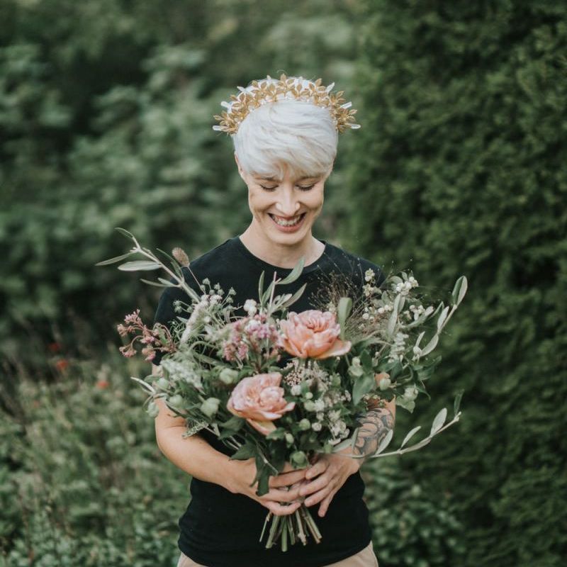 Bride with short hair wearing a gold crown and holding a bridal bouquet