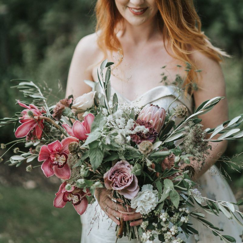Bride with red hair holding a dusky pink wedding bouquet