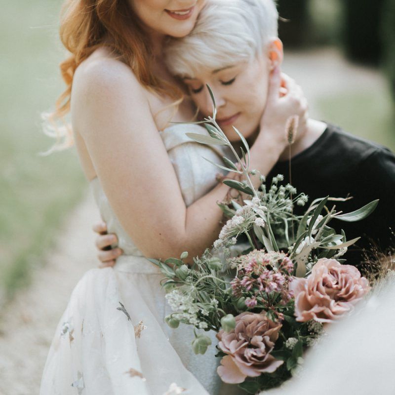 Bride and bride embracing at Castle Combe Manor House in Wiltshire