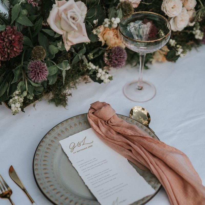 Place setting with charger plate, coloured napkin and menu card