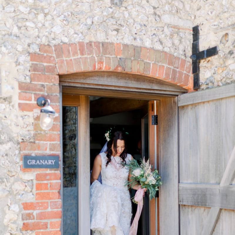 Bride makes her way to wedding ceremony carrying gorgeous bouquet