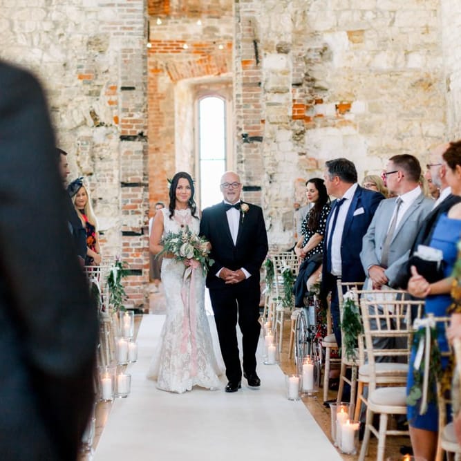 Bride walks down the aisle at Lulworth Castle wedding