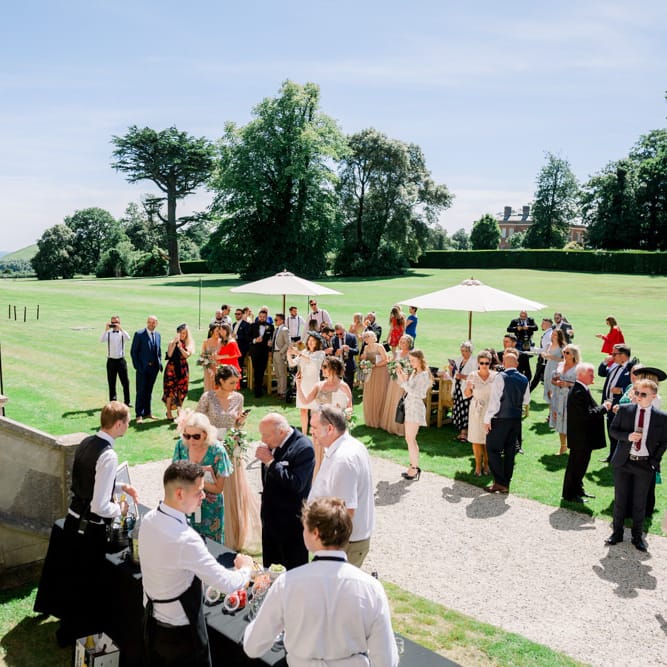 Guests enjoy drinks on the lawns of Lulworth Castle
