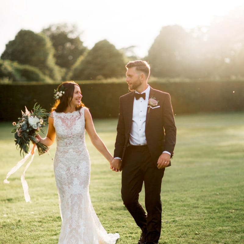 Lace wedding dress and black tuxedo for Lulworth Castle wedding