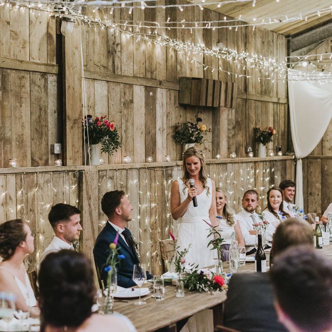 Bride speech at vegan wedding with fairy light backdrop