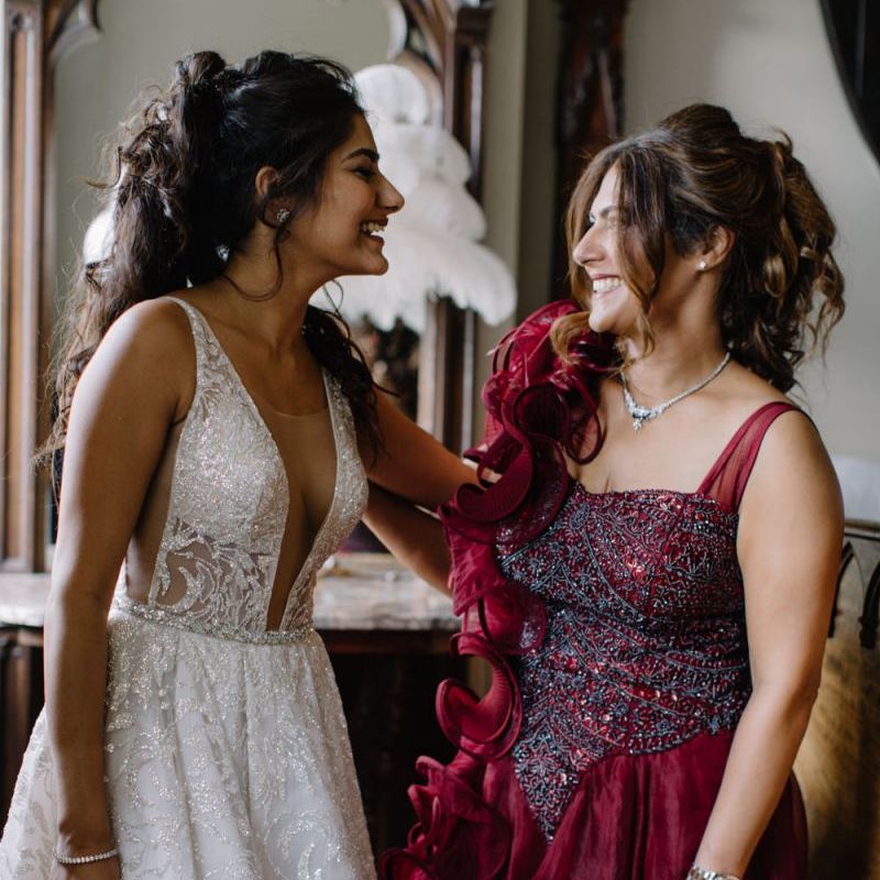 Bride in Berta Bridal gown with friend in red ball gown