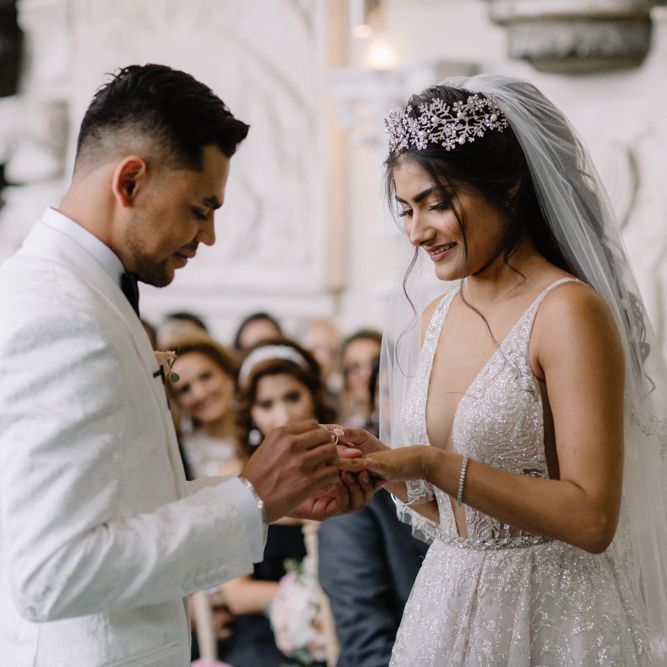 Bride and groom exchanging rings with bride in Berta Bridal gown