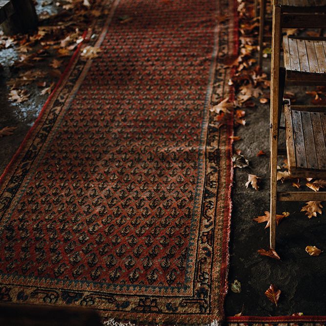 Persian Rugs and Autumn Leaves Lining Aisle | Rustic Wooden Chairs | Mariachi Band and Persian Rug Aisle for Autumn Wedding | Leah Lombardi Weddings