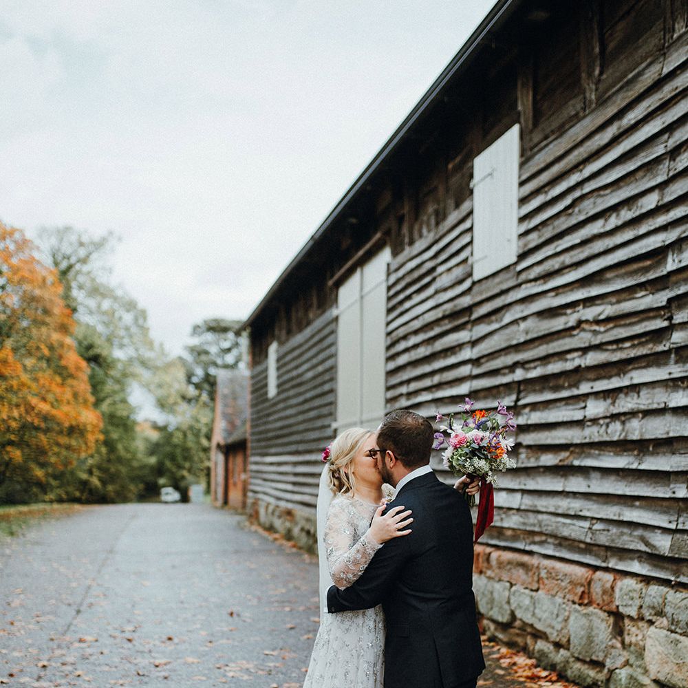 Bride in Bead Embellished Needle &amp; Thread Gown with Cascading Tulle Skirt and Semi Sheer Sleeves | Elbow Length Veil | Bridal Up Do with Pink Hair Flowers | Groom in Check Blue Three Piece Suit by T.M.Lewin with Maroon Tie and Pocket Square | Purple, Orange and Pink Flowers with Foliage and Maroon Trailing Ribbon | Pimhill Barn Wedding Venue | Mariachi Band and Persian Rug Aisle for Autumn Wedding | Leah Lombardi Weddings