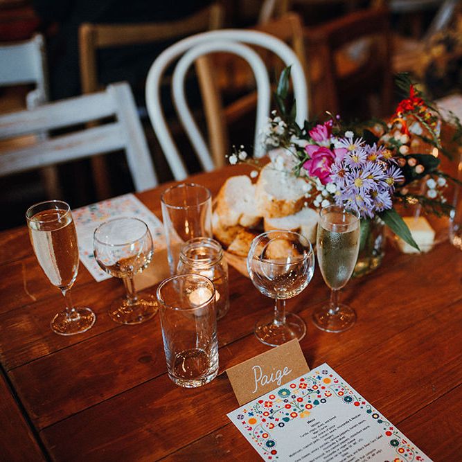 Wooden Banquet Tables | Mismatched Rustic Chairs | Tea Lights in Jars | Kraft Place Settings | Wedding Breakfast Menus | Purple and Pink Table Flowers | Mariachi Band and Persian Rug Aisle for Autumn Wedding | Leah Lombardi Weddings