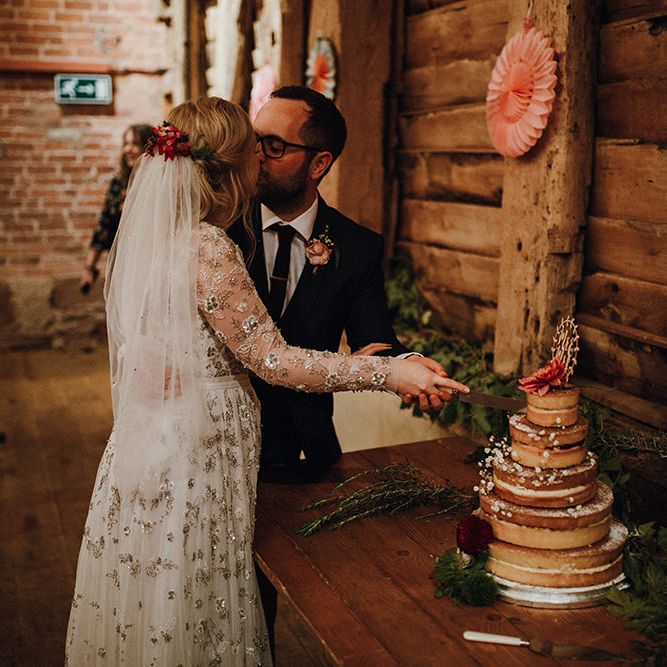 Bride in Bead Embellished Needle &amp; Thread Gown with Cascading Tulle Skirt and Semi Sheer Sleeves | Elbow Length Veil | Bridal Up Do with Pink Hair Flowers | Groom in Check Blue Three Piece Suit by T.M.Lewin with Maroon Tie and Pocket Square | Naked Wedding Cake from Waitrose | Wooden Mr and Mrs Cake Topper | Paper Fans | Cutting of the Cake | Mariachi Band and Persian Rug Aisle for Autumn Wedding | Leah Lombardi Weddings