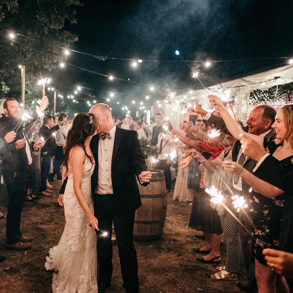 Sparklers On Wedding Exit. Marquee in Jersey. Foliage Installations. Stationery by Quints of Jersey. Bride Wears Enzoani. Photography by Max Burnett