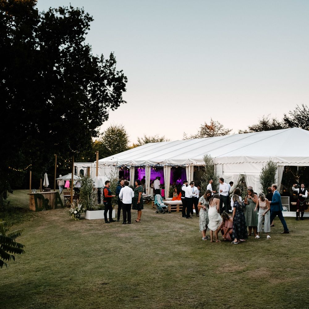 Marquee In The Evening. Enchanted Forest Theme . Florals and Foliage Installations by Eden by Claire | Quints of Jersey Stationery | Bride Wears Enzoani | Images by Max Burnett
