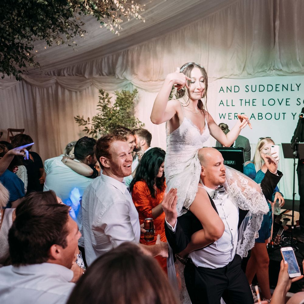 Bride Dancing. Large Format Printing and Signage. Marquee in Jersey. Foliage Installations. Stationery by Quints of Jersey. Bride Wears Enzoani. Photography by Max Burnett