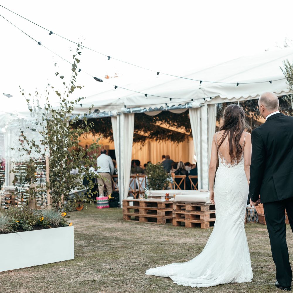 Enzoani Backless Dress. Marquee in Jersey. Foliage Installations. Stationery by Quints of Jersey. Bride Wears Enzoani. Photography by Max Burnett