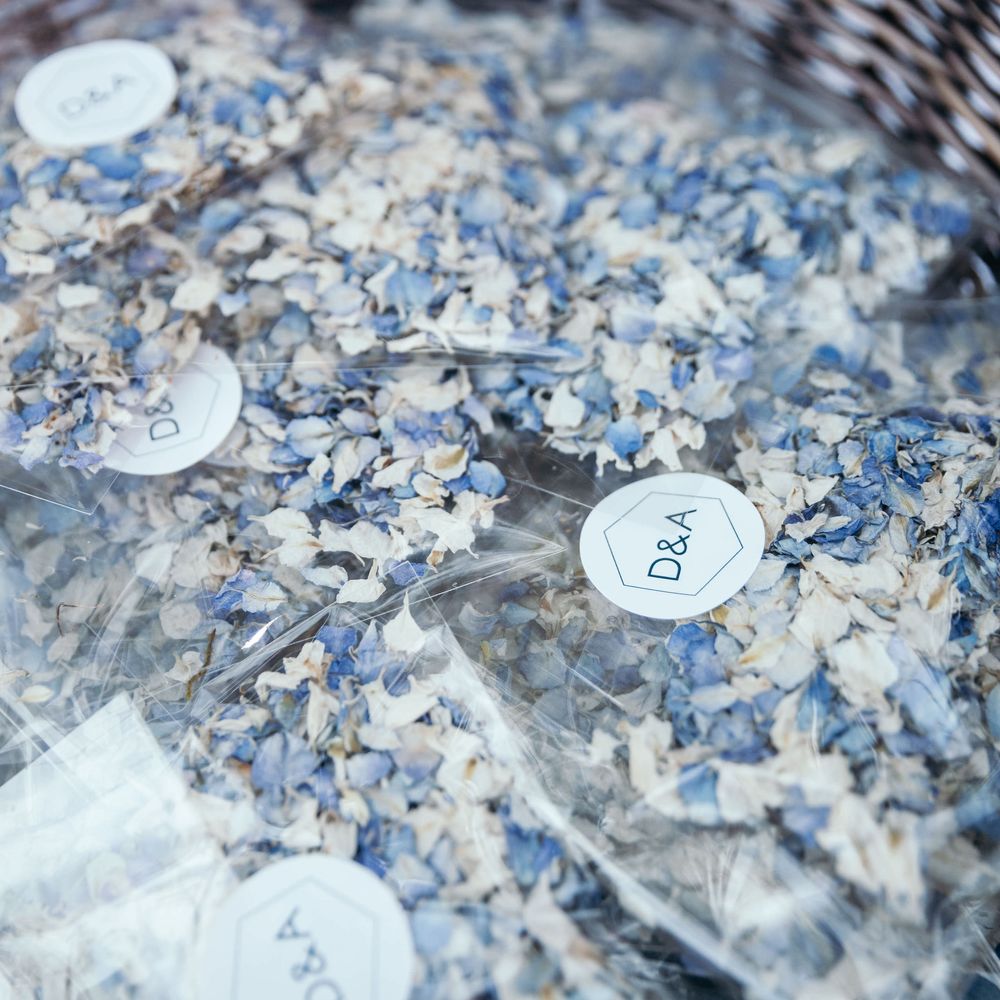 Blue and Cream Floral Confetti. Marquee in Jersey. Foliage Installations. Stationery by Quints of Jersey. Bride Wears Enzoani. Photography by Max Burnett