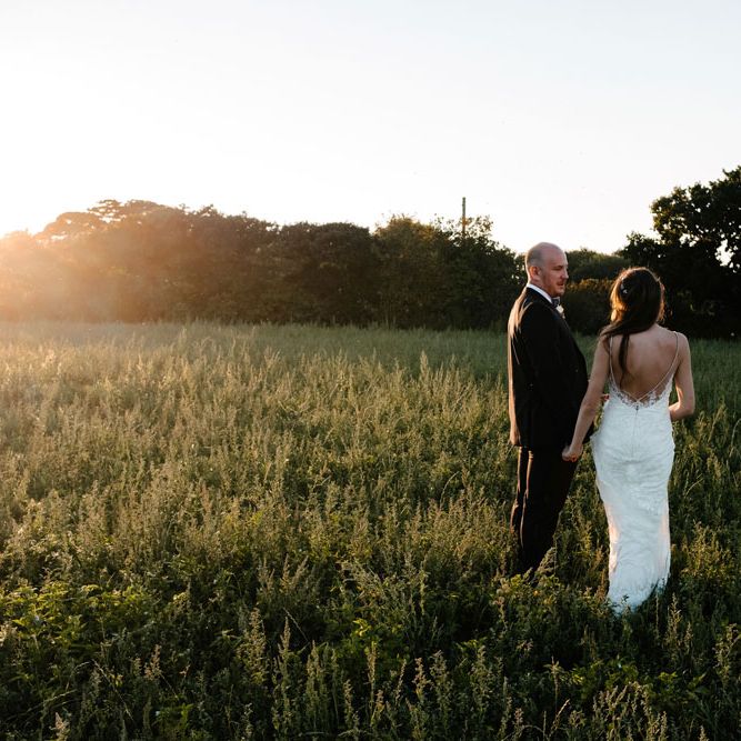 Enzoani Backless Dress. Marquee in Jersey. Foliage Installations. Stationery by Quints of Jersey. Bride Wears Enzoani. Photography by Max Burnett