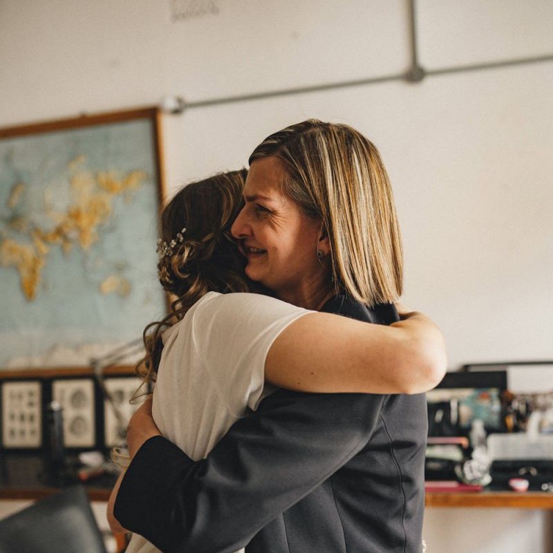 Mother of the bride and daughter hugging on the wedding morning