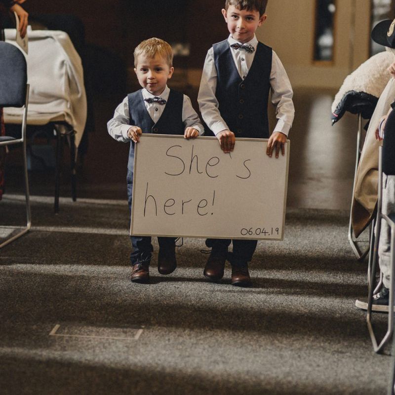 page boys with 'She's Here' sign