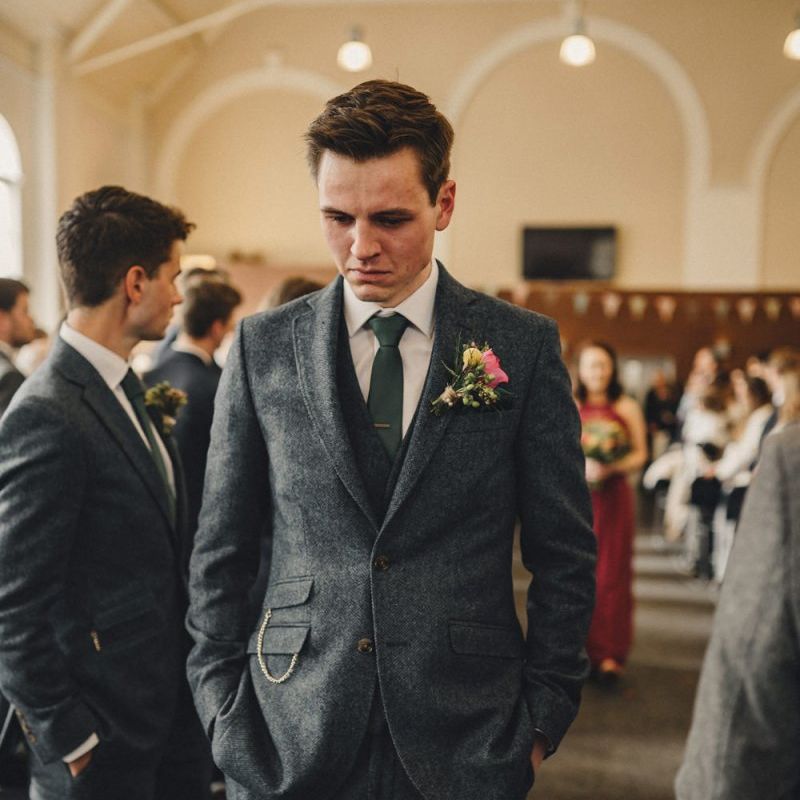 Emotional groom in blue wool suit waiting for his bride to arrive