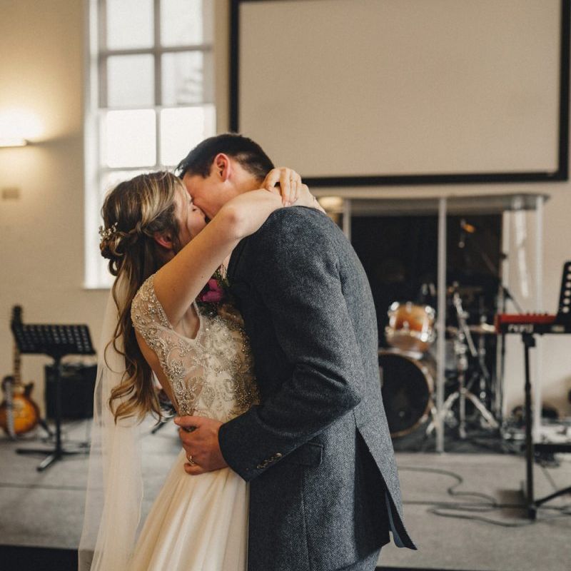 Bride and groom kissing at the altar