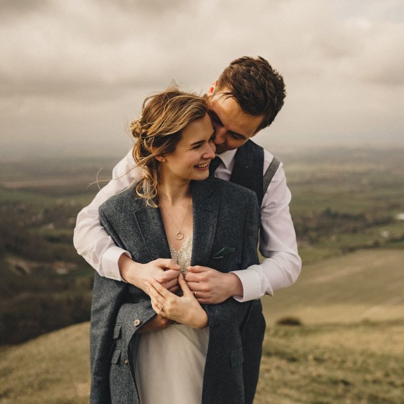 groom wrapping his bride in a jacket to keep her warm
