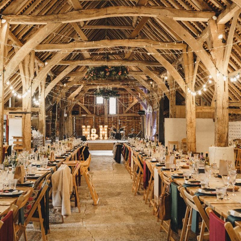 Rustic barn wedding reception with string lights and colourful flowers