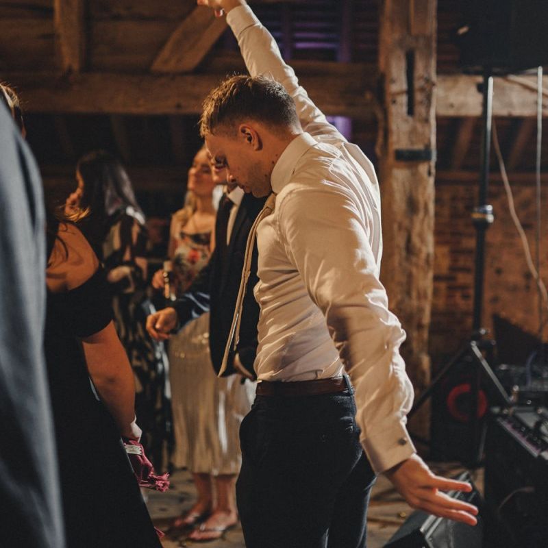 Wedding guests dancing at the rustic barn evening reception